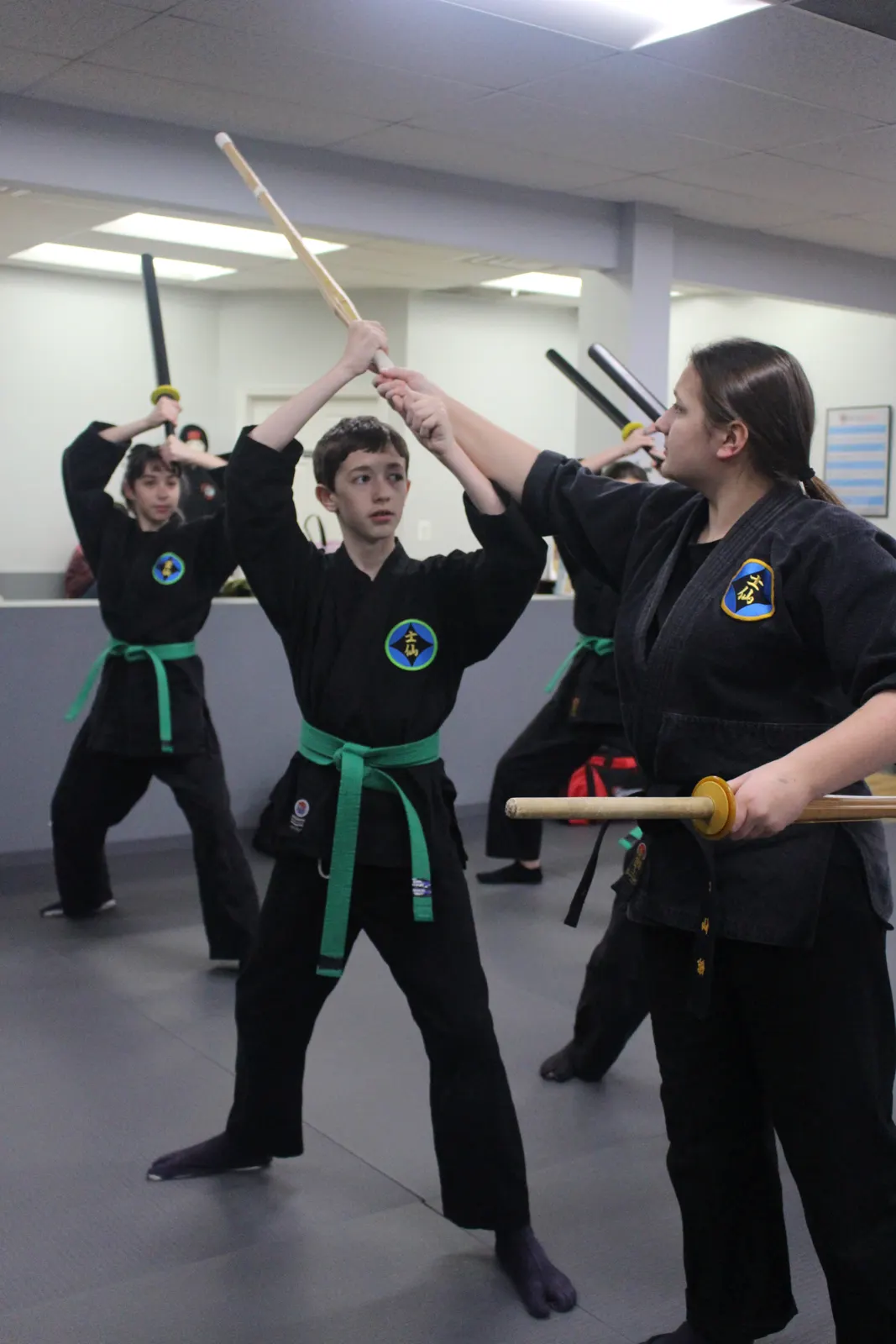 Teen jujutsu students training with bo staffs