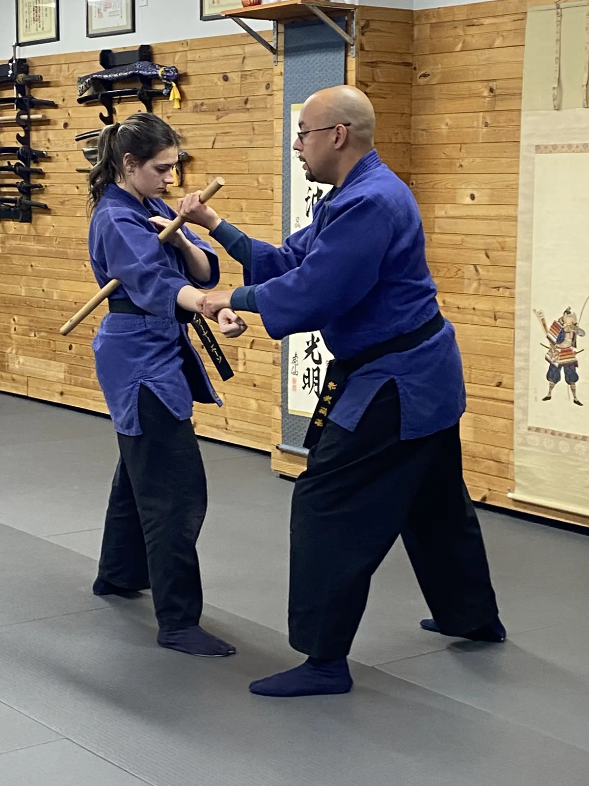 Sensei Luis Martinez coaching an adult student in bo staff technique